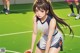 A girl in a basketball uniform holding a basketball on a court.