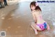 A woman in a pink bikini sitting on the beach.