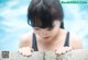 A woman leaning over the edge of a swimming pool.
