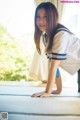 A woman in a sailor outfit crouching on the floor.