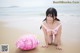 A woman in a pink bikini laying on the beach.