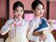 A couple of young women dressed in traditional Korean clothing.